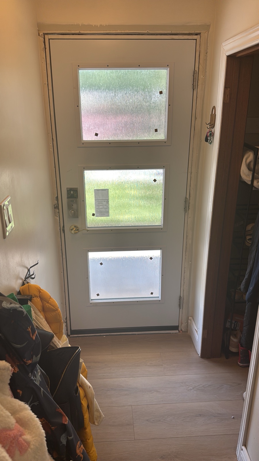 New steel entry door with three-lite glass insert, set into a rebuilt frame