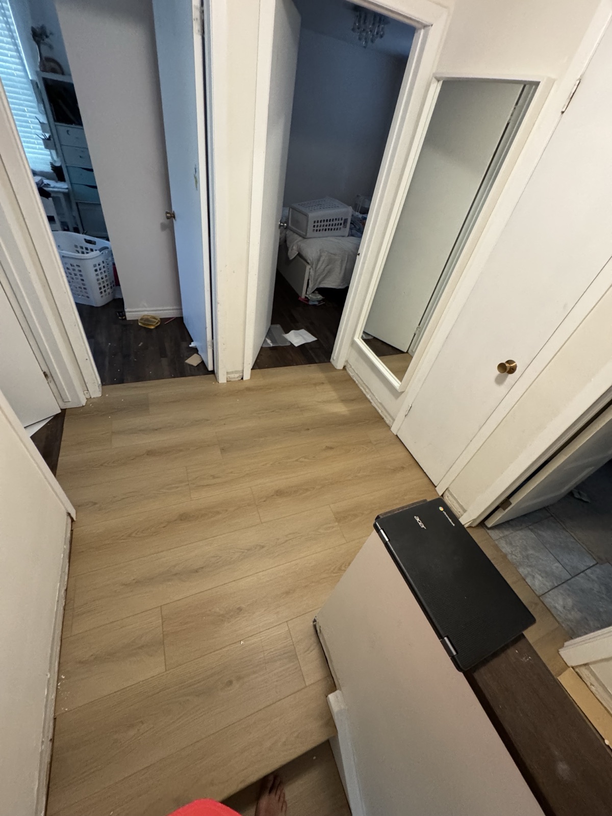 Upstairs hallway with new wide-plank laminate flooring run through the doorways